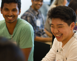 Students smiling while sitting at a table