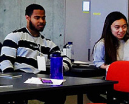 People in classroom focusing on speaker at front of room